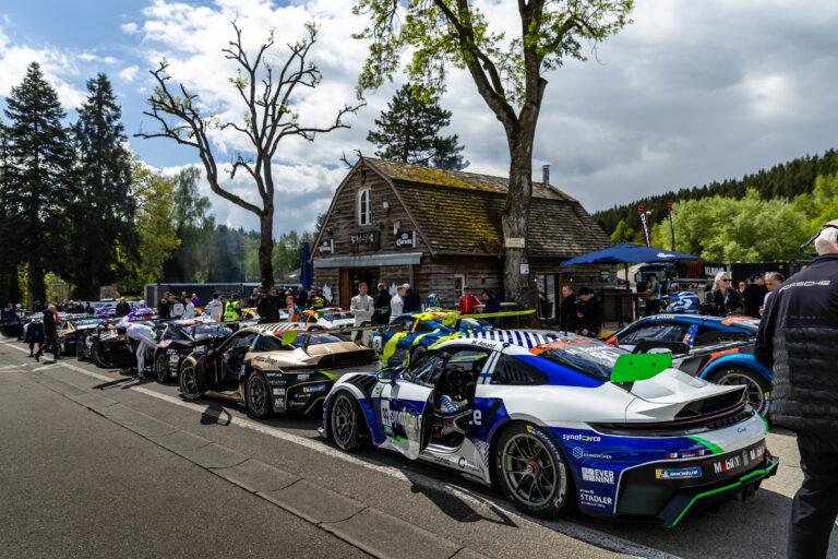 Synaforce-Porsche Nr. 99 von Proton Competition in der Boxengasse von Spa-Francorchamps mit deutlich sichtbarem Evernine-Media-Logo, Aufstellung neben weiteren PSCCD-Autos