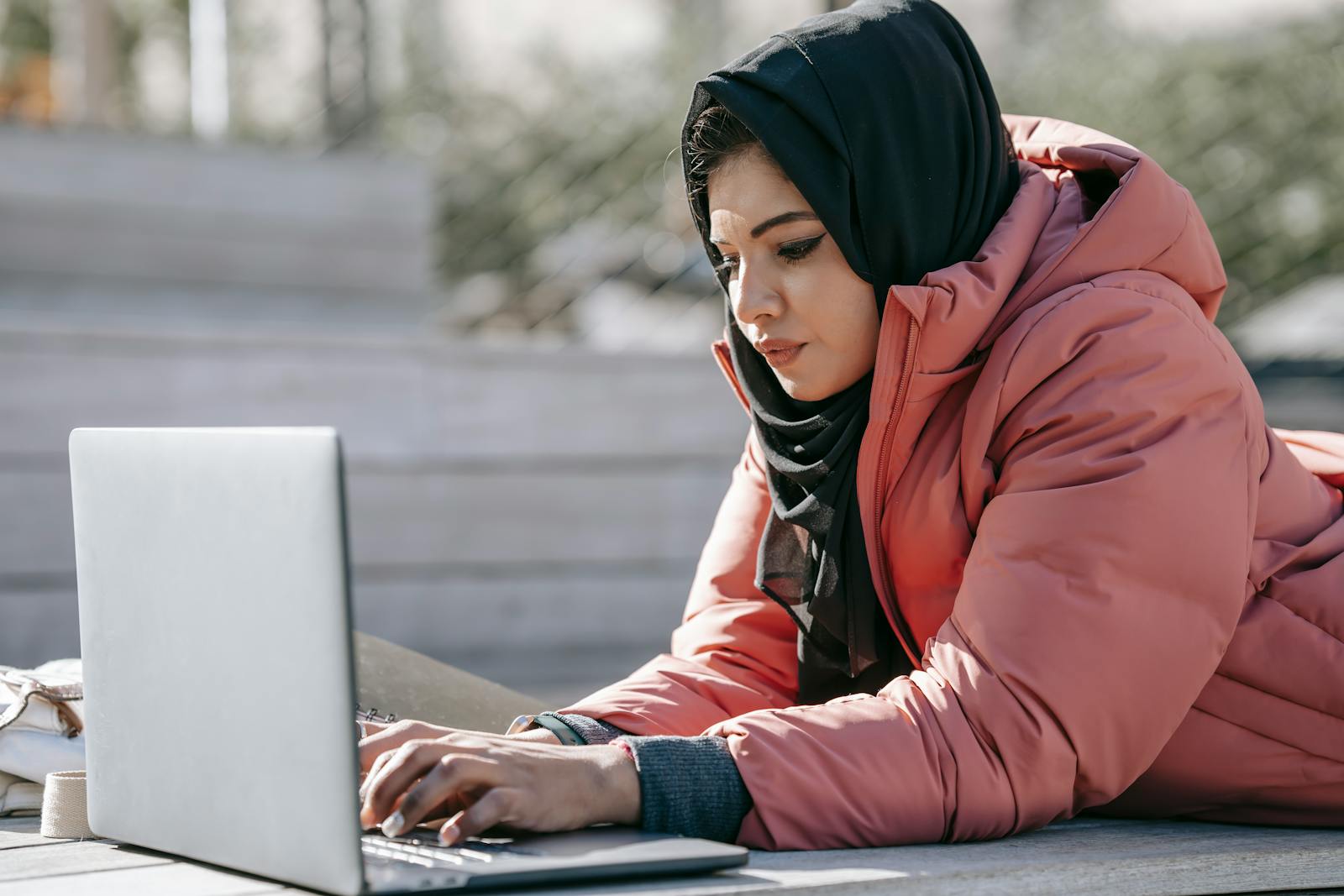 Person recherchiert am Laptop, casual Outdoor-Setting, sinnbildlich für Erstkontakt-Suche im Recruiting